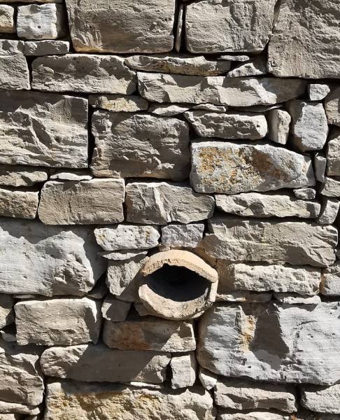 Pose d'une sarbacane dans un mur habillé en pierre dans le Lubéron